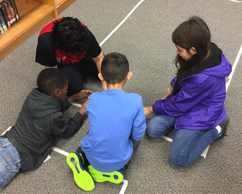 Students learning to code with a Bee-bot. 