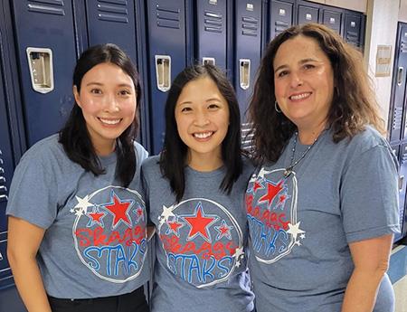 The Skaggs 3rd Grade team standing and smiling in front of blue lockers in their soft blue Skaggs Spirit t-shirts.