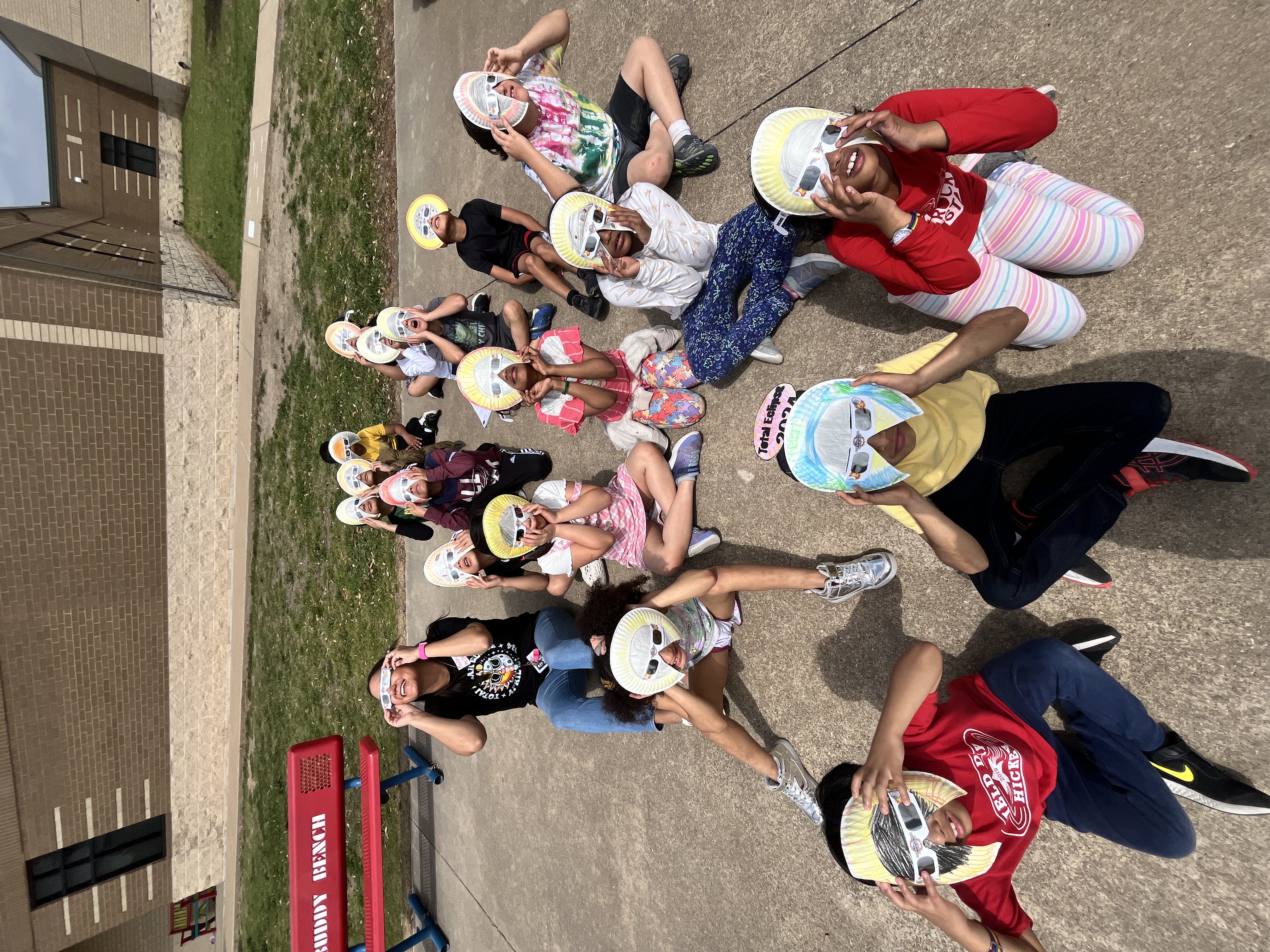 Students watching the solar eclipse wearing sunglass masks.