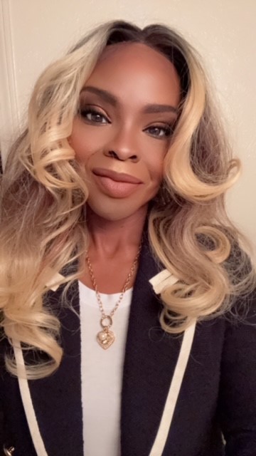 Woman smiling at the camera with long blond hair.