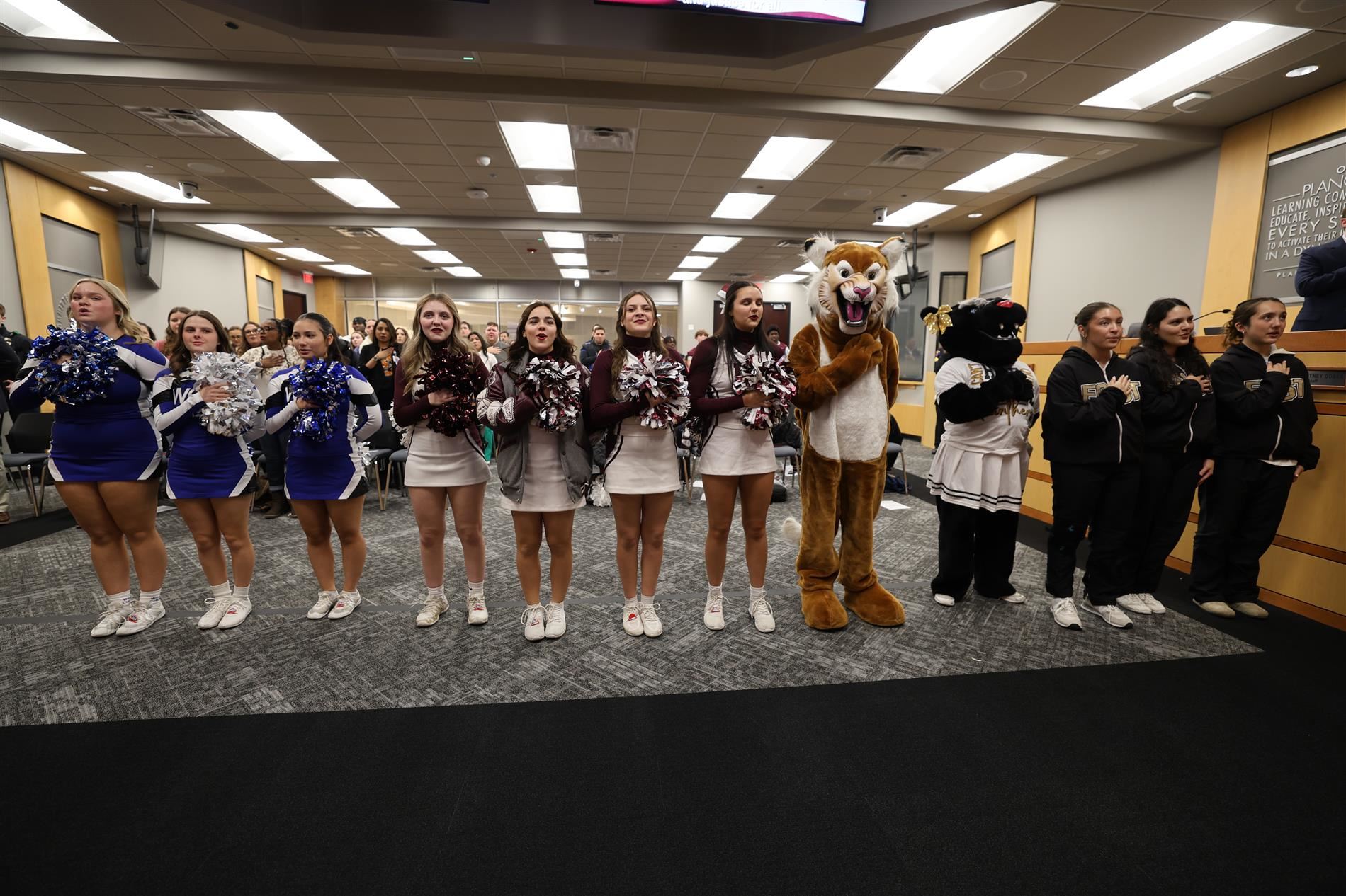 Cheerleaders and mascots perform the pledge of allegiance 