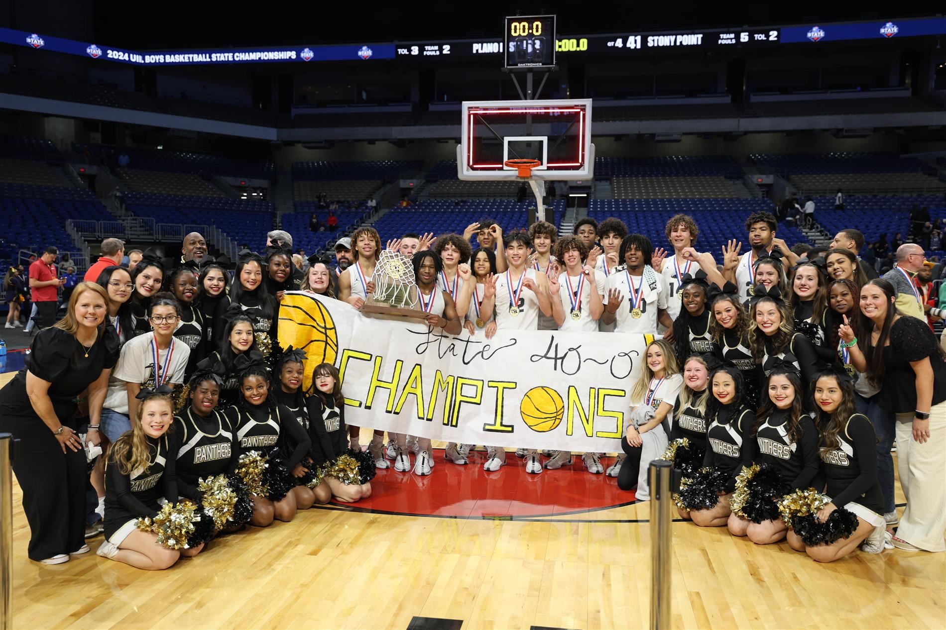 image of plano east basketball players, and cheerleaders with sign