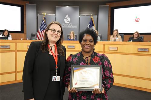 Kaya Jones holding certificate presented by Board Vice President Dr. Lauren Tyra