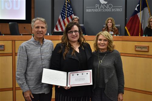 Nicole Vickerman with her mother and father, posing with board recognition certificate