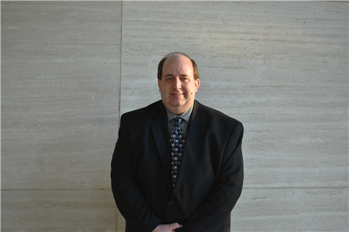 Greg Grimes posing outside the Plano ISD Administration building