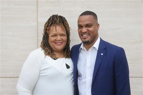 portrait photo of a man with his mother to his left, in front of a white marble background