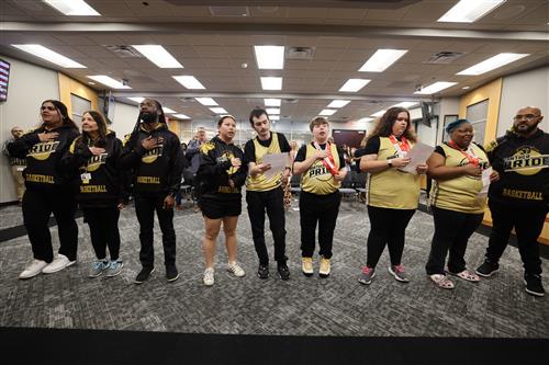 Members from Panther Pride in front of the board of trustees reciting the pledges of allegiance 