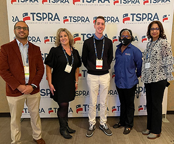  Communications Department Team: Standing in front of a TSPRA step-and-repeat