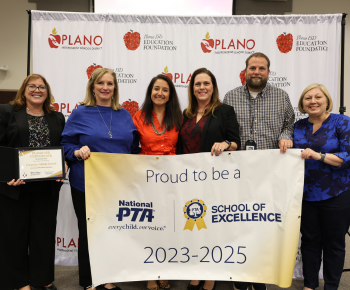  A group of individuals standing with a National PTA School of Excellence banner
