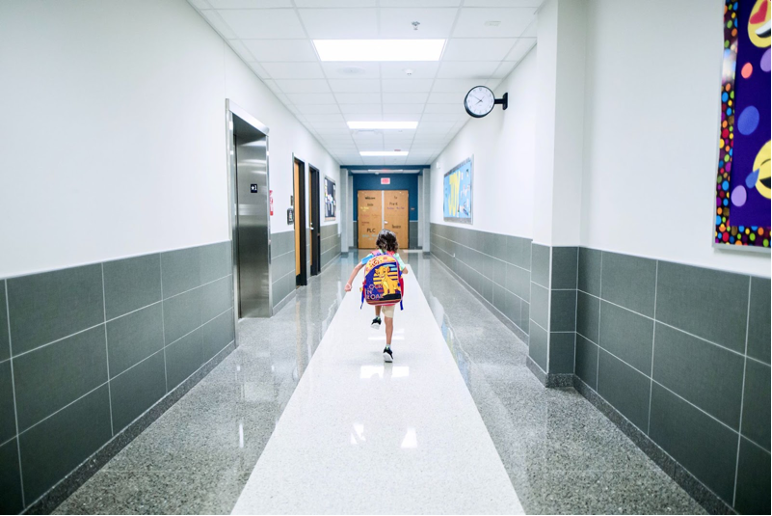 One student walking down the hallway.