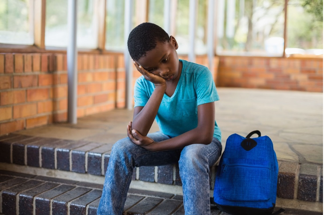Student on steps with hand to face