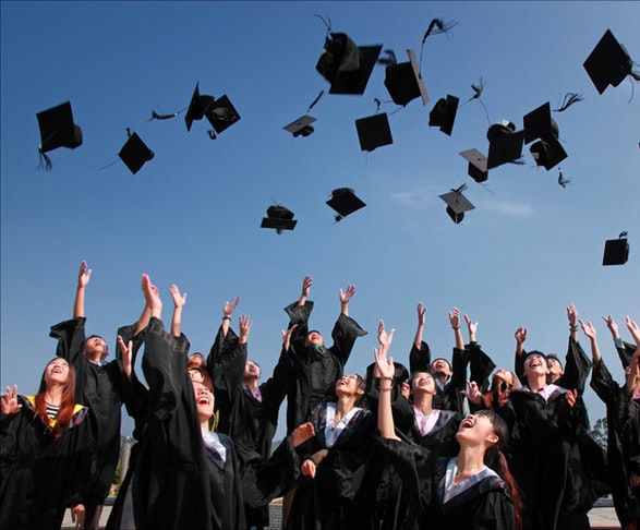  graduates tossing caps in the air