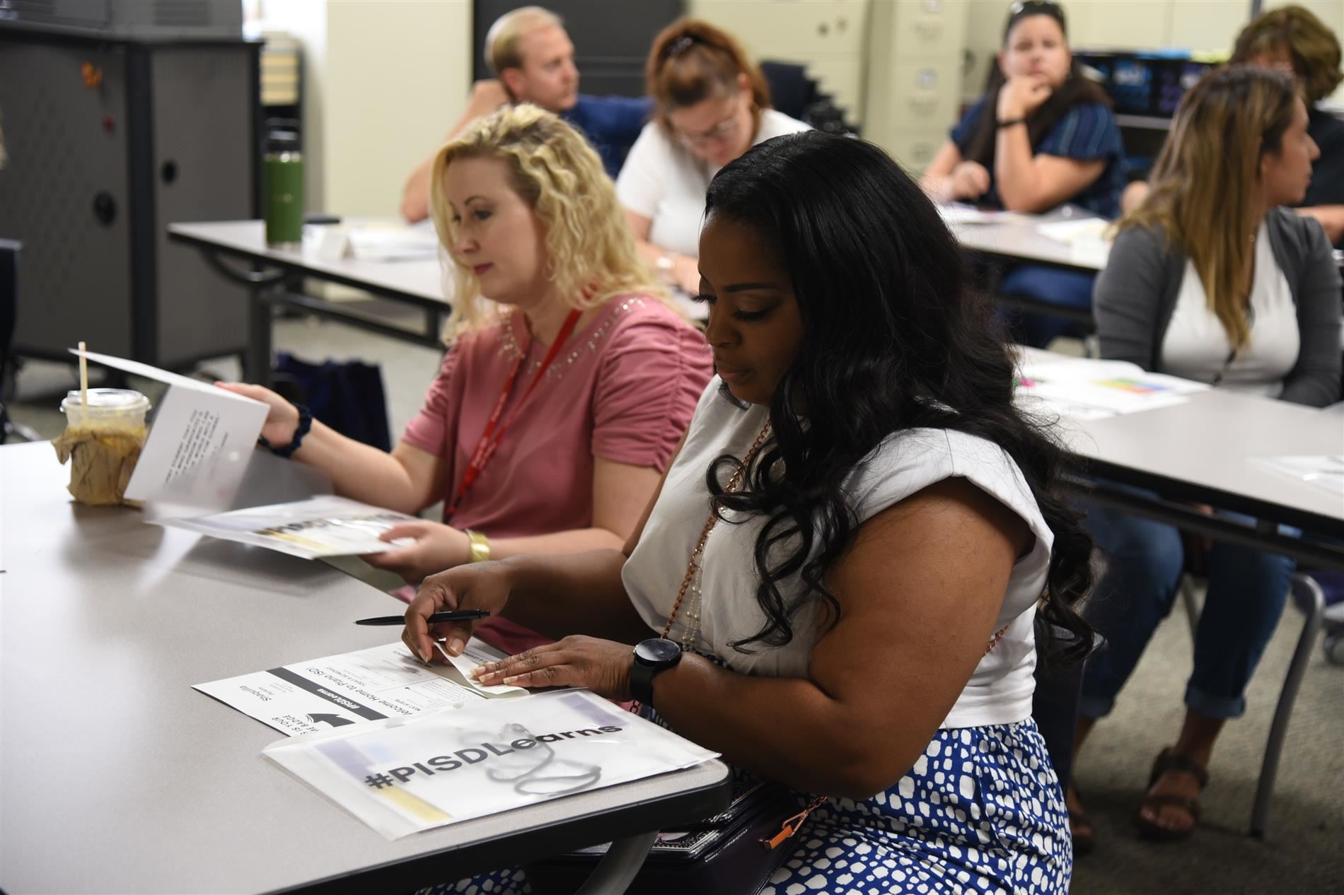 New Teacher training - several teachers working at classroom desks