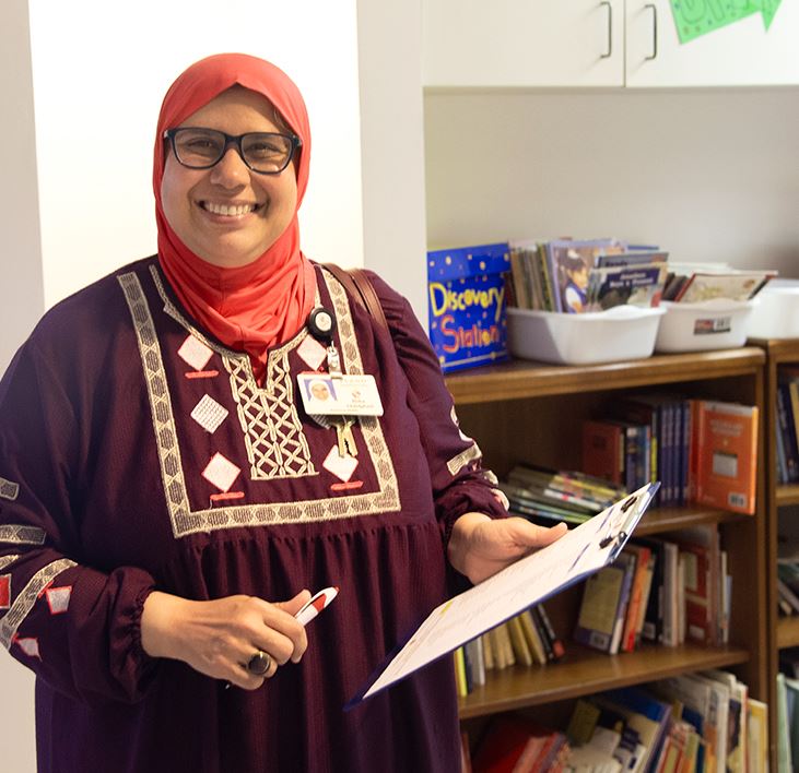 Smiling female teacher with shopping list and free books