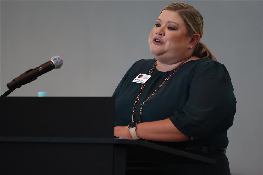 Brittnea Ussery, Sr. Executive Dir. PISDEF, speaking at event podium