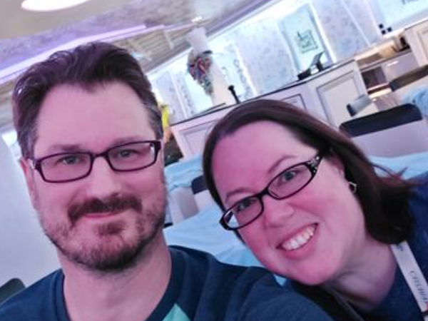 A white man and a white woman pictured with their heads together. In the background is a restaurant. This is Mr. and Mrs. Hoffmann.